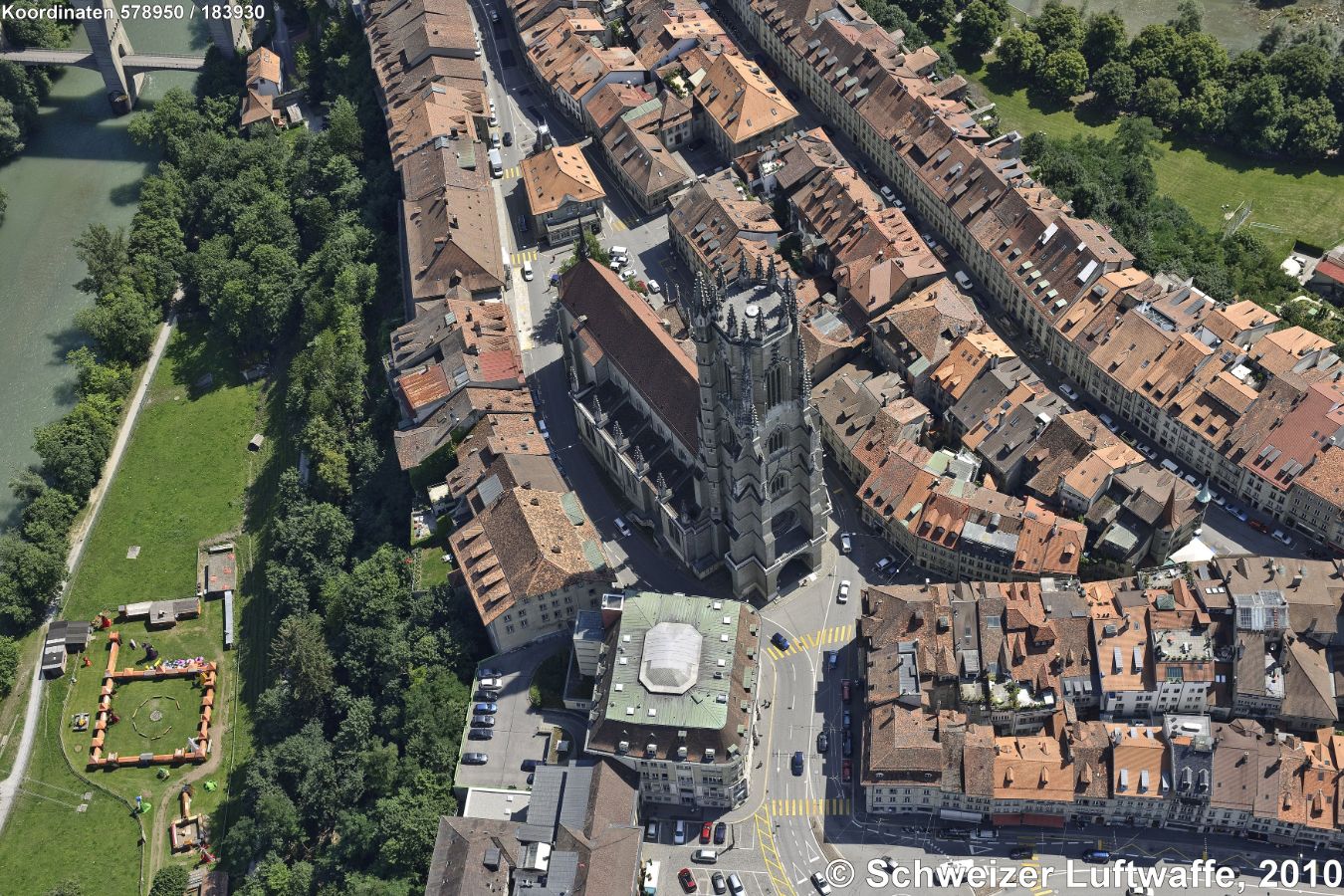 Fribourg, Cathédrale Saint Nicolas (N: links), erbaut ab 1283 in mehreren Etappen bis 1490. Dreischiffige, gotische Kirche ('Flamboyangotik'). Rechts im Bild: von W nach E verlaufende Grand-Rue.
